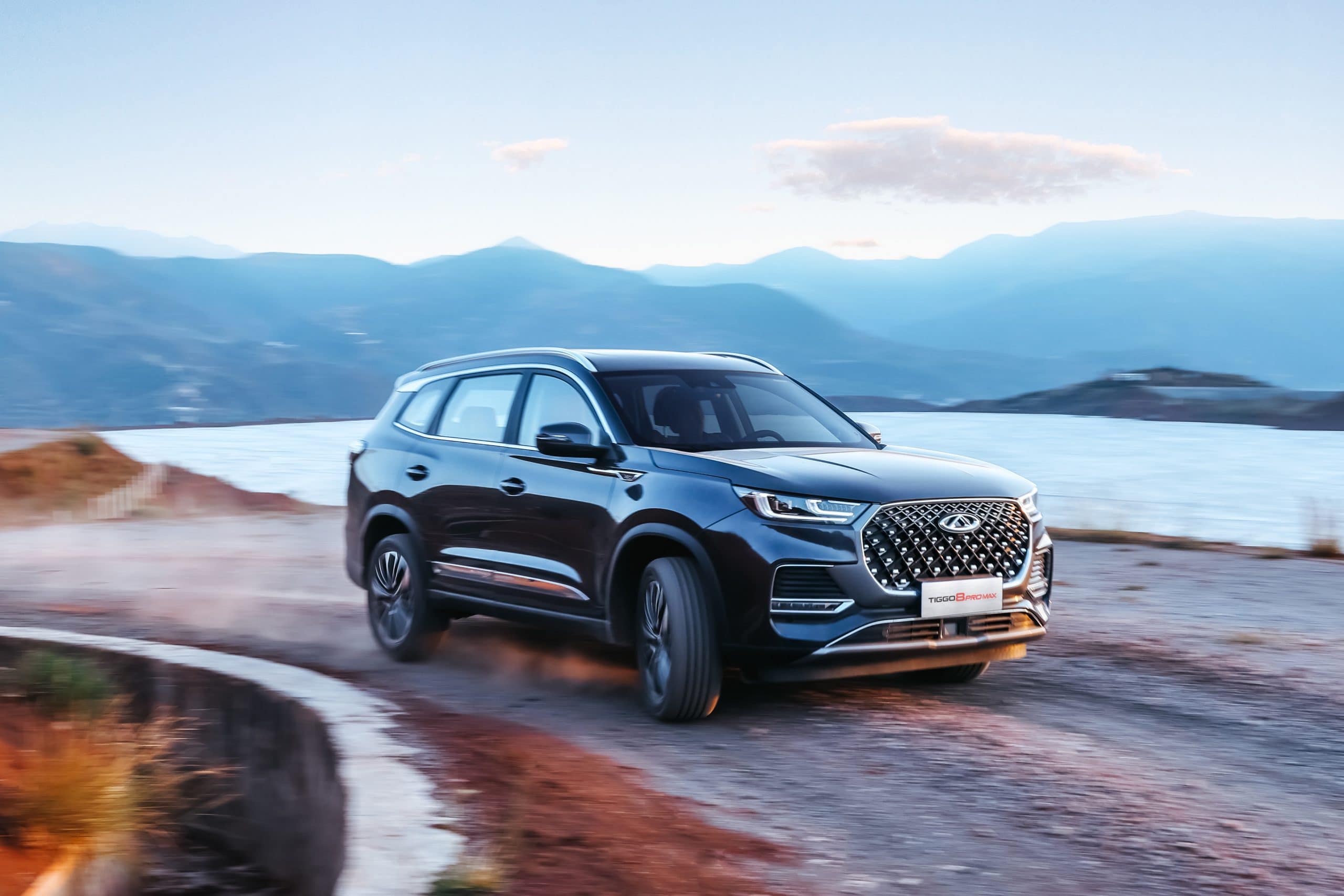 SUV negro de Salfa Sur Automotriz en camino de montaña con lago y montañas de fondo.