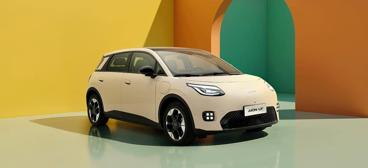 Coche eléctrico compacto en exhibición con fondo colorido.