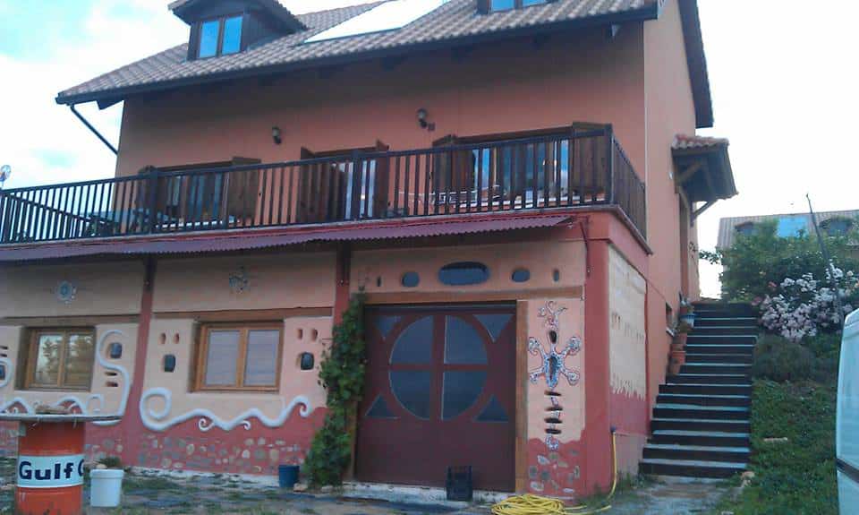 Two-storey house with artwork on exterior walls and balcony.