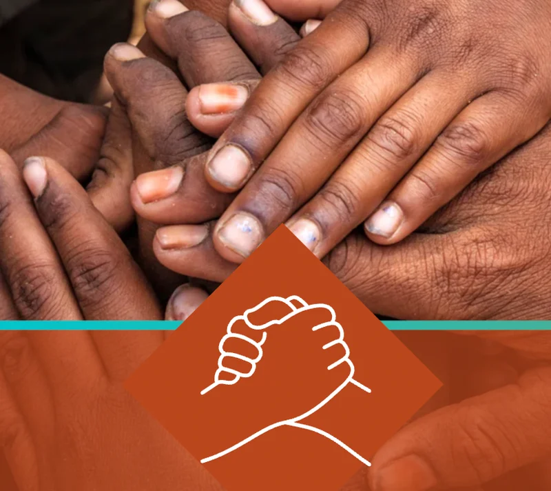 Group of diverse hands together symbolising community and resilience.