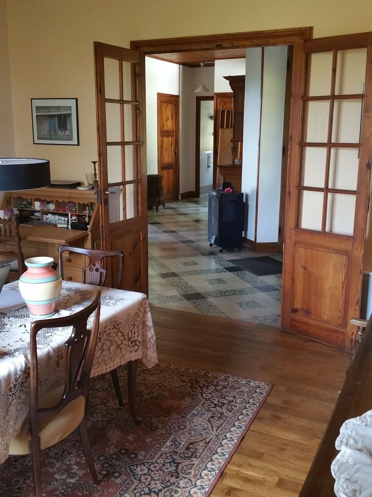 Interior of a traditional dining room with wooden furniture and open French doors.