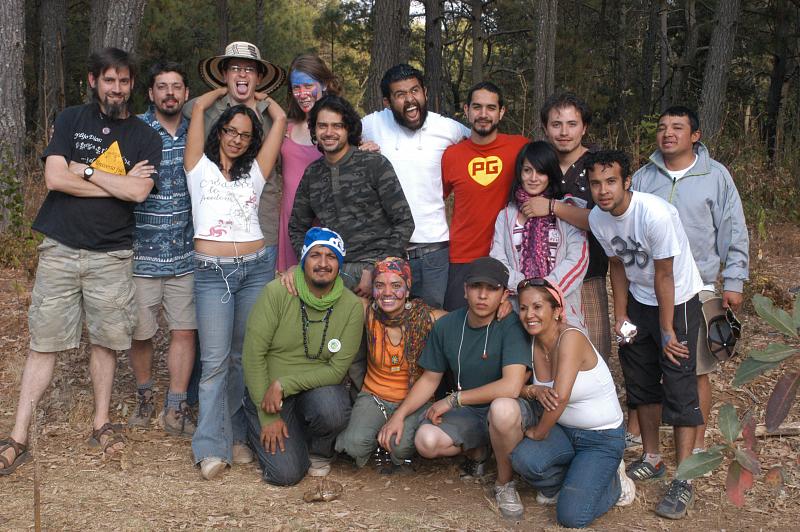 Group of diverse volunteers outdoors, smiling in a forest clearing.