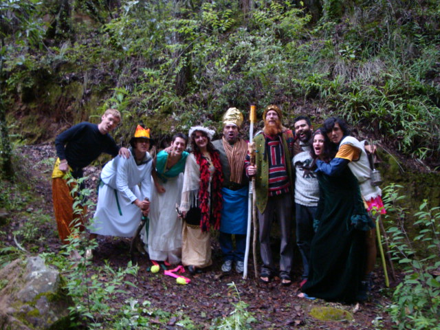 Group of people in forest wearing colorful robes and crowns.