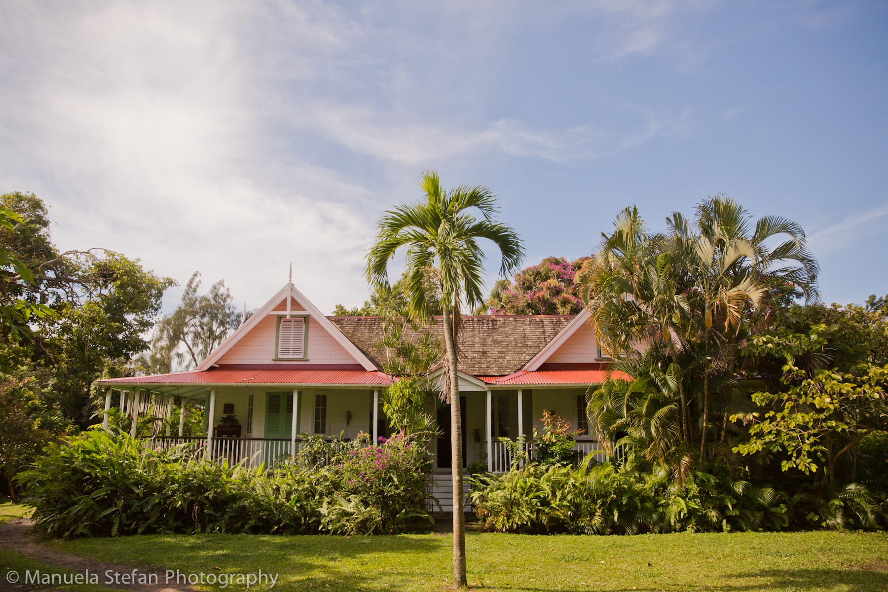 Eco village cottage with tropical garden and palm trees, classic veranda.