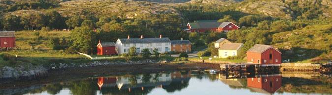 Historic coastal village with colorful houses reflected in calm water.