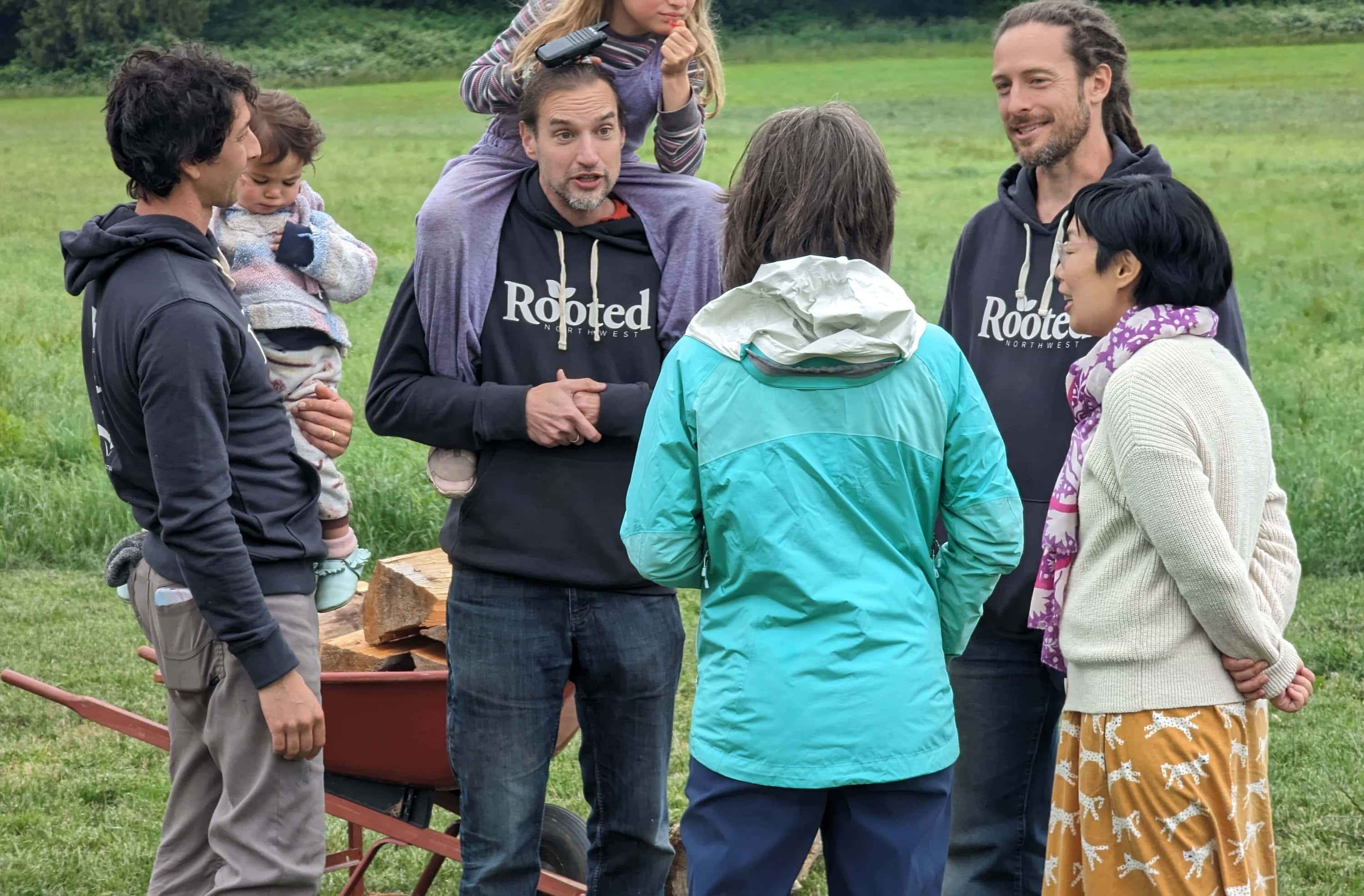 Group of diverse people in an outdoor ecovillage setting.