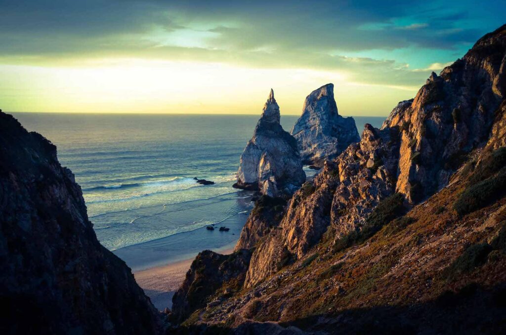 Coastal rocks along the shoreline with sea and sunrise light.
