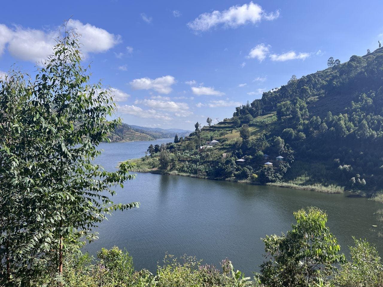 Scenic lakeside village on a hillside with calm water and blue sky.