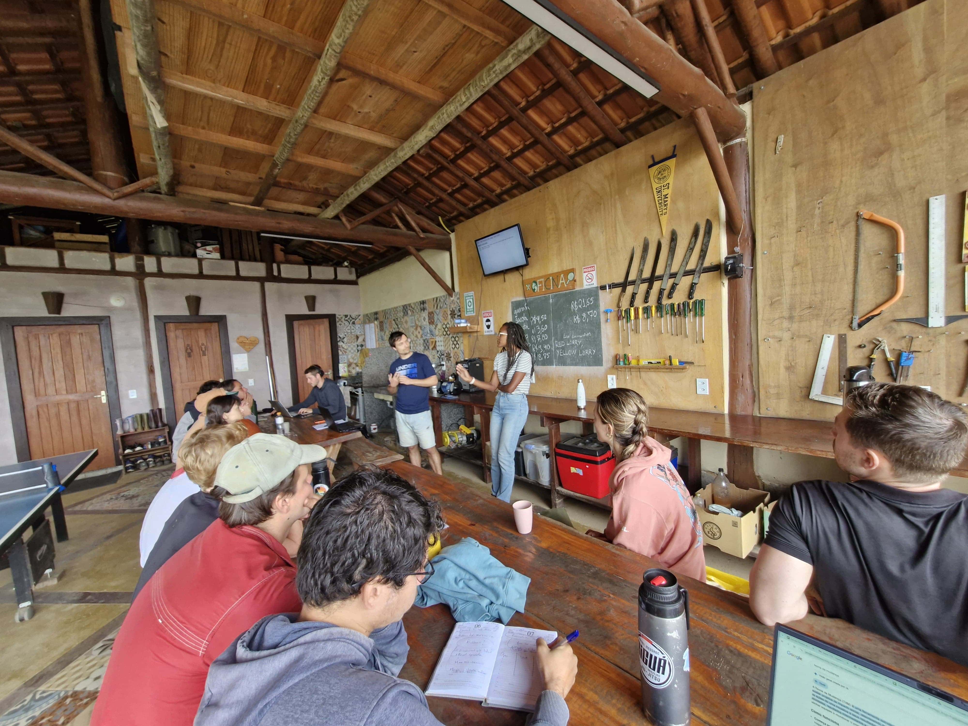 Group of people in a workshop at Eco Caminhos with presenters at the front.