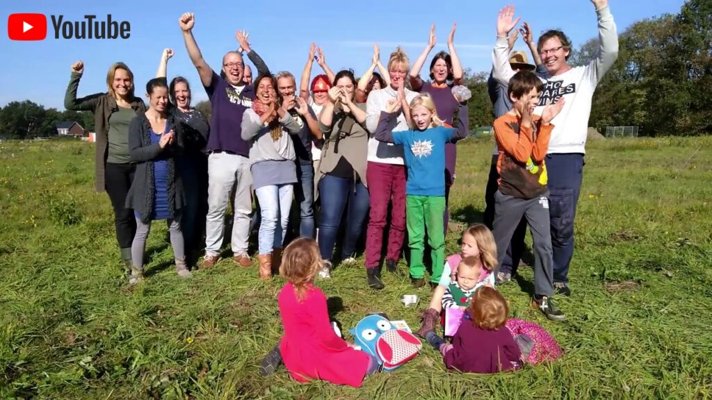 Group of people outdoors celebrating in a field for Global Ecovillage Network.