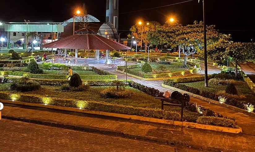 Night view of a lit park garden with pathways and benches.