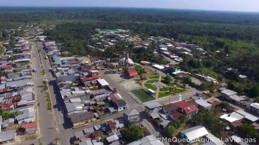 Aerial view of a village with streets, houses and green spaces.