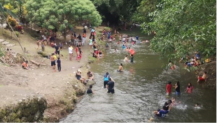 People by a riverbank participating in a community gathering.
