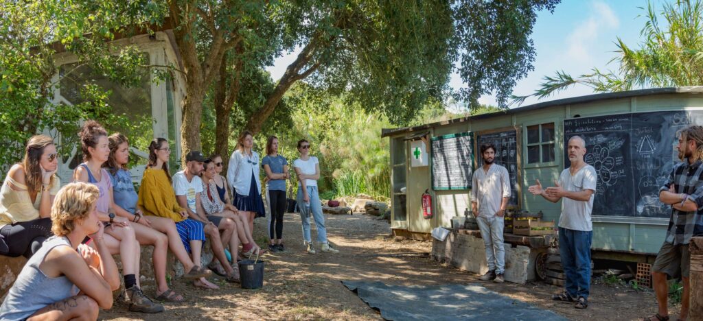 Group of people at Terra Alta Permaculture Education Centre discussing outdoors.