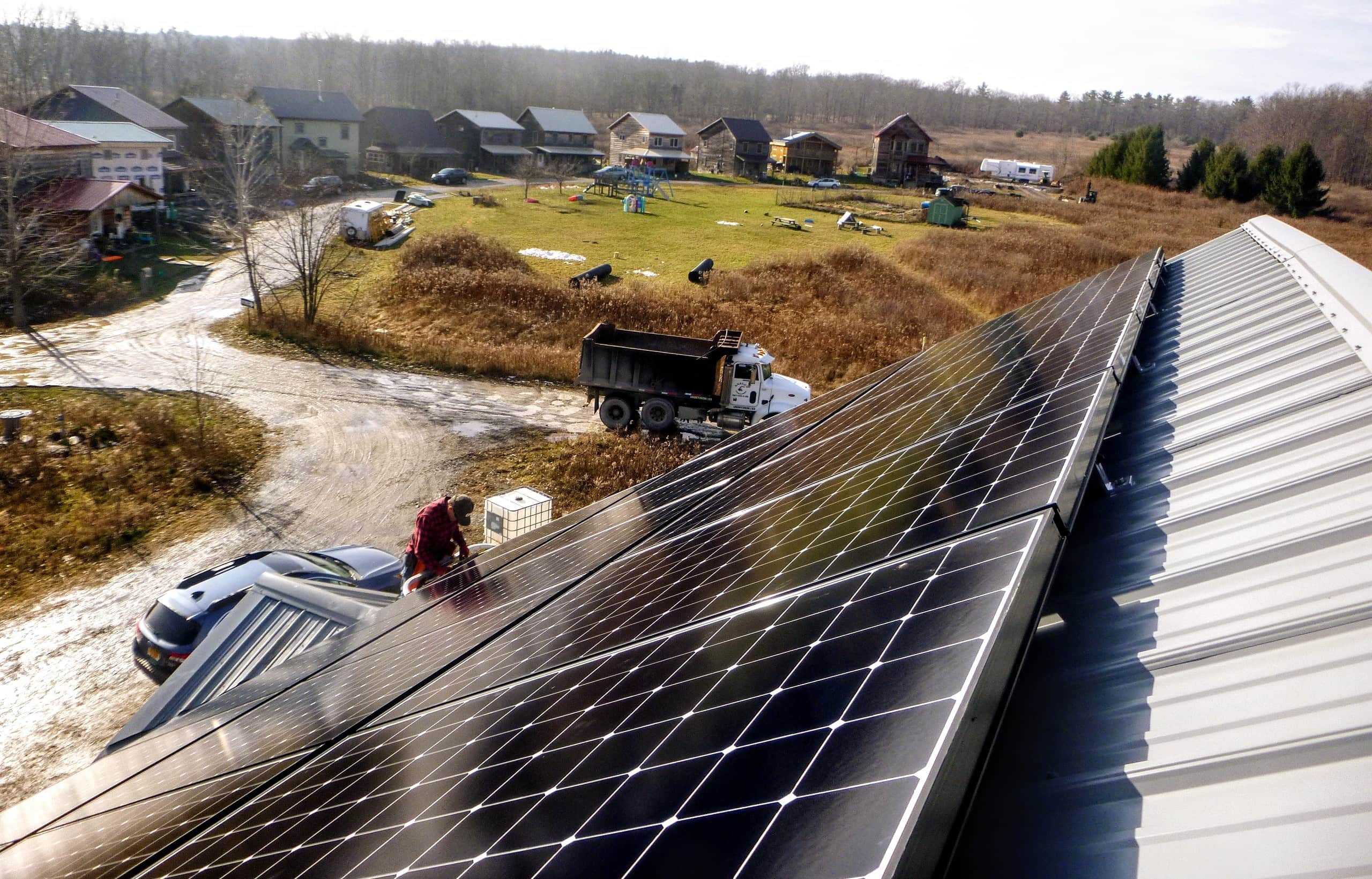 Solar panels on a rooftop powering a sustainable ecovillage.