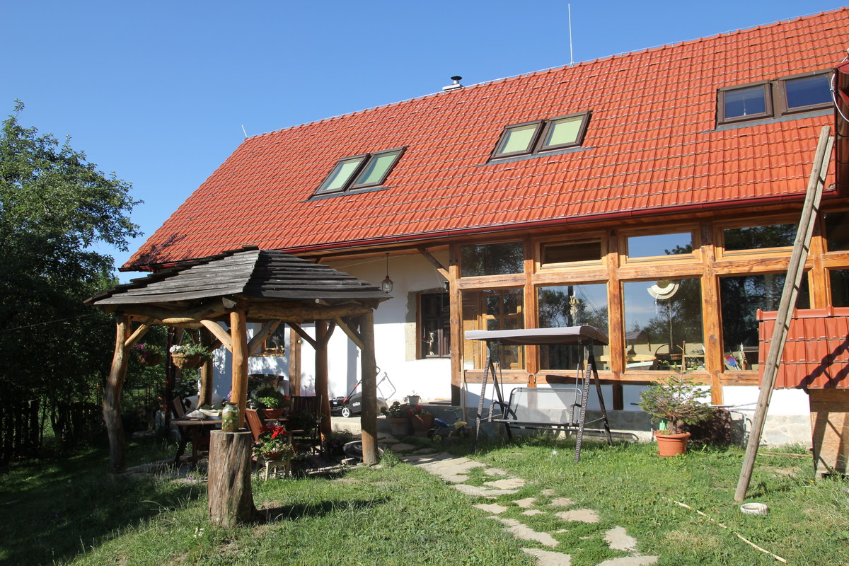 Eco lodge in the White Carpathians with red tiled roof and wooden veranda.