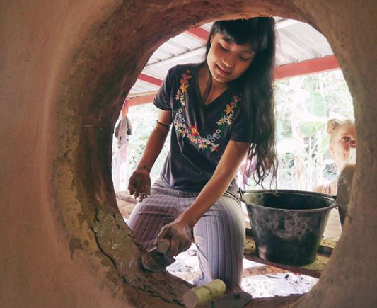 Craftsman shaping clay in a circular kiln at Gaia Ashram.