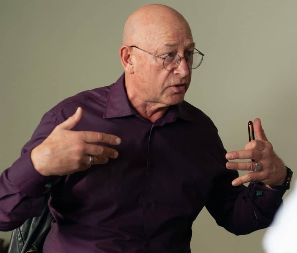 Man speaking passionately in a meeting about sustainable communities.