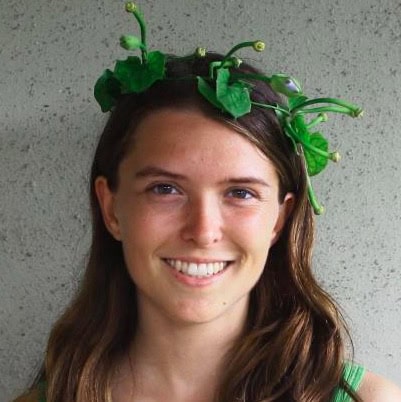 Portrait of a smiling woman with a leafy crown.