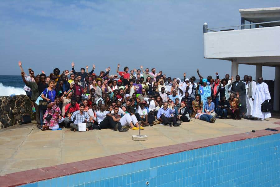 Global Ecovillage Network gathering in Dakar with diverse participants by the pool.