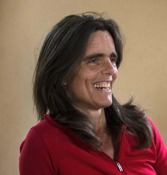 Smiling woman in red top, warm portrait for the Global Ecovillage Network.