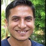 Portrait of a smiling man in a blue shirt outdoors.