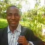 Portrait of a man in a garden with trees and water.