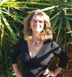 Portrait of a woman outdoors among green plants for Global Ecovillage Network SEO.