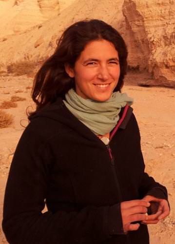 Portrait of a woman outdoors with desert cliffs in background.