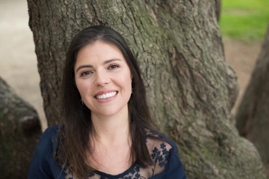 Róisín Dexter smiling outdoors near a tree for Global Ecovillage Network.