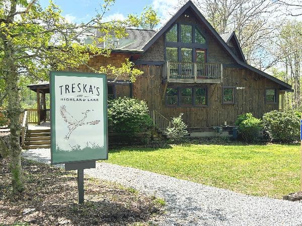 Exterior view of Treska's Highland Lane, a rustic lodge with wooden facade and greenery.