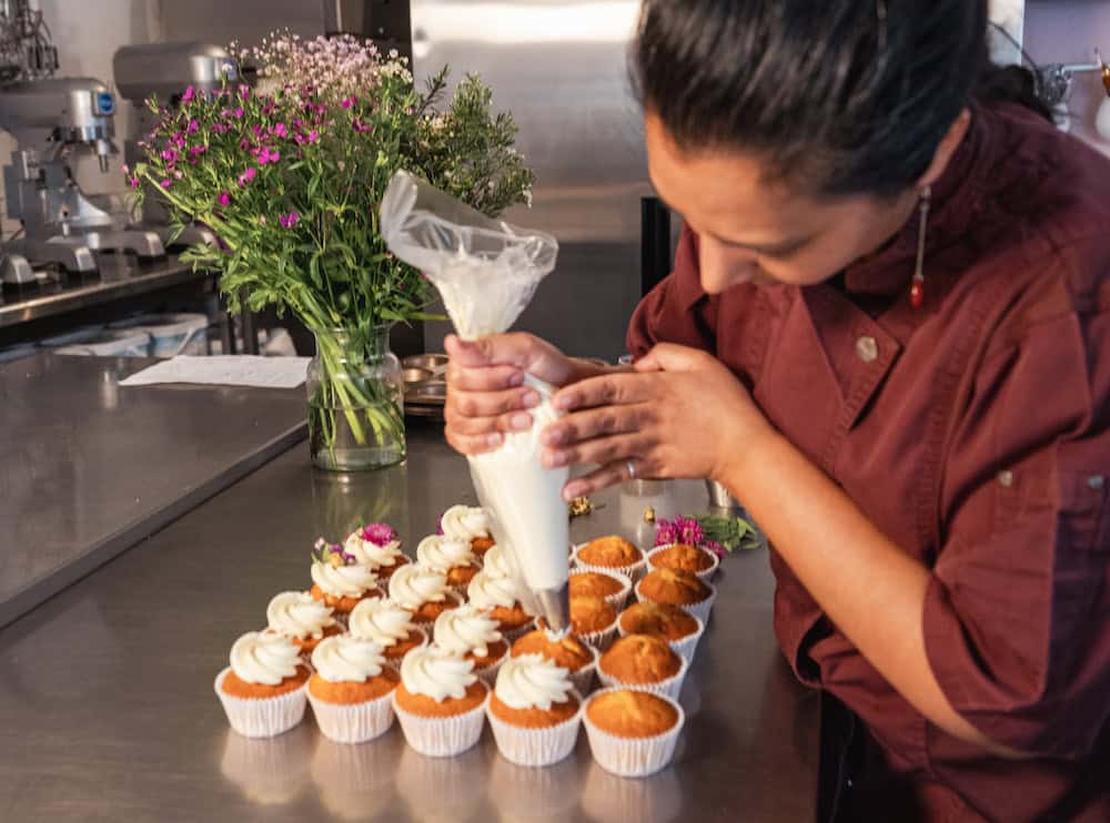 Een foto van Faryel die een cupcake aan het versieren is.