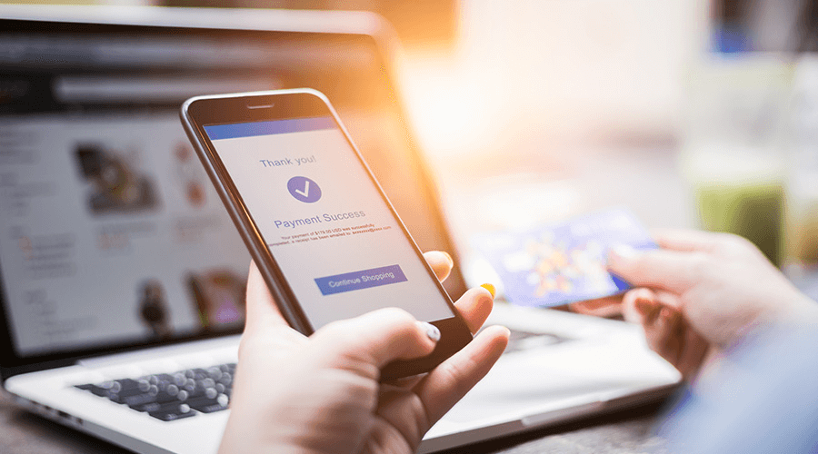 A person holding a smartphone with a "Payment Success" message on the screen, representing efficient financial operations and outsourced accounting services.