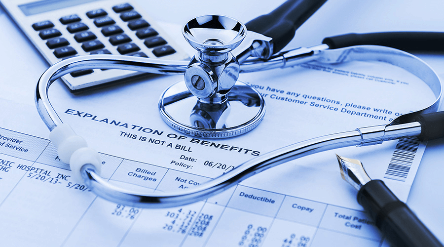 A stethoscope and calculator placed on an "Explanation of Benefits" form, representing financial consulting for medical practices and business financial management.