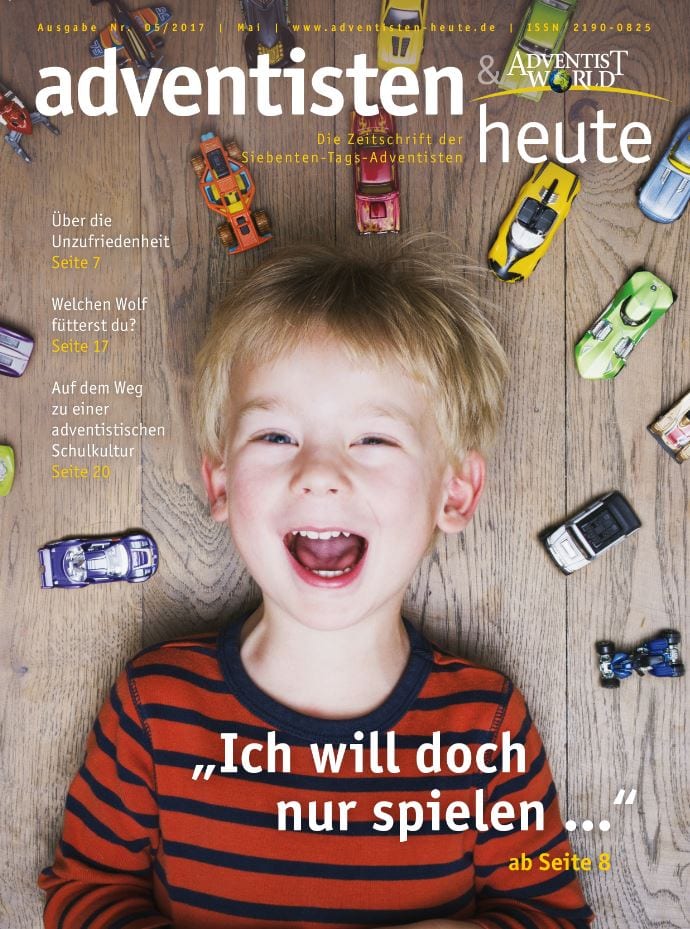 Spielendes Kind mit Spielzeugautos auf Holzfußboden, fröhlich und lachend, passend für christliche Familien und Kinderkirchen, ideal für evangelische Kinderliteratur und adventistische Themen.