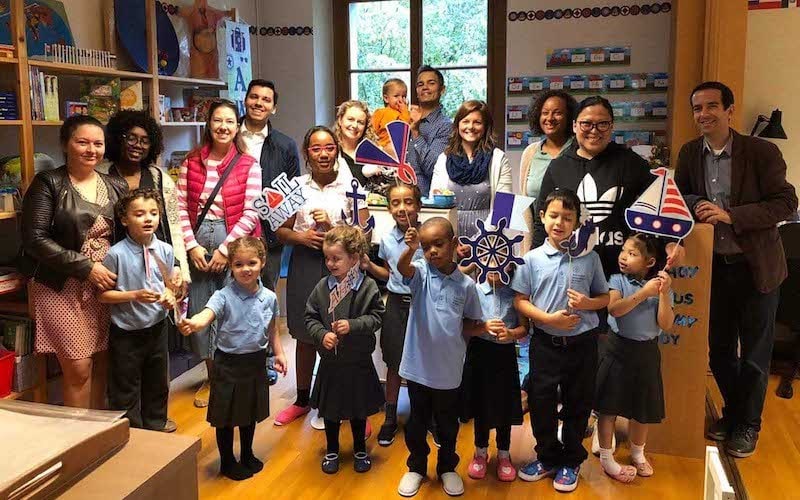 Ein Gruppe von Kindern und Erwachsenen in einer Buchhandlung, die maritime Dekorationen und Spielzeug hält, symbolisiert Lesefreude und gemeinsames Lernen bei Advent-Verlag.