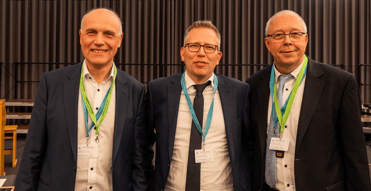Menschen bei einer Konferenz, die für einen Verlag arbeiten, in formeller Kleidung und mit Namensschildern, professionelle Atmosphäre, Fokus auf Verlag, Kinder- und Jugendbücher, christliche Literatur, christlicher Verlag, Weihnachtsbücher, Verlagsszene, advent-verlag.de.