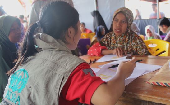 Menschen im Gespräch bei einer sozialen Hilfsorganisation, vermutlich beim Austausch über Projekte und Unterstützung, mit Fokus auf humanitäre Hilfe, Bildung und soziale Integration.