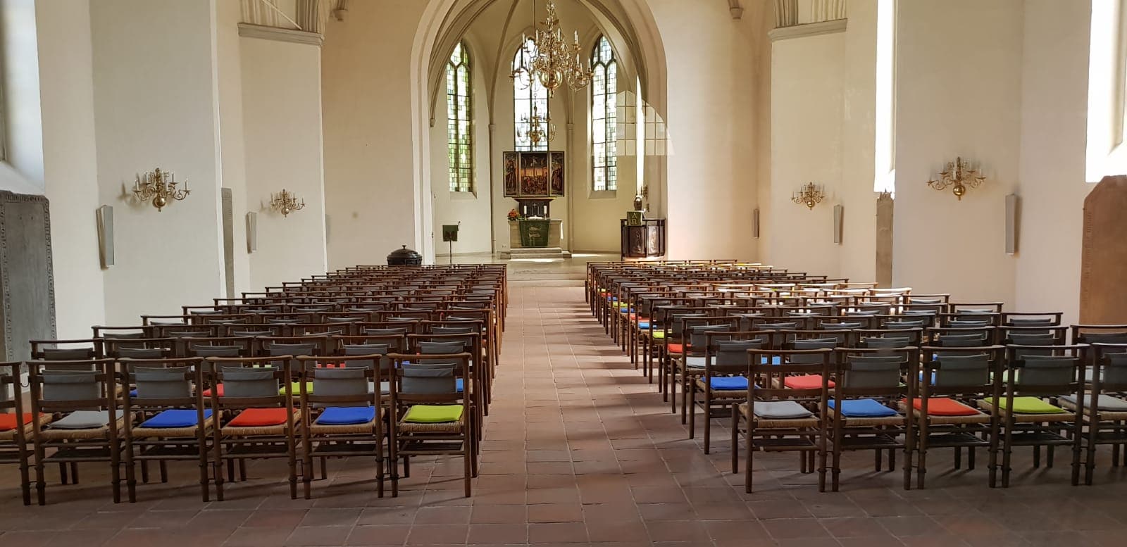 Ruhige Kirche Innenansicht mit Stühlen, Altar, Kirchenfenstern und Kronleuchtern, ideal für religiöse Veranstaltungen, Gebet und Gottesdienste, Fokus auf Spiritualität und Gemeinschaft, lutherische Kirche.