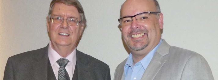 Zwei Männer im Business-Anzug lachen und posieren für ein Foto bei Advent-Verlag, Christliche Literatur, religiöse Bücher, Gemeinschaftsveranstaltung, professionelle Darstellung.