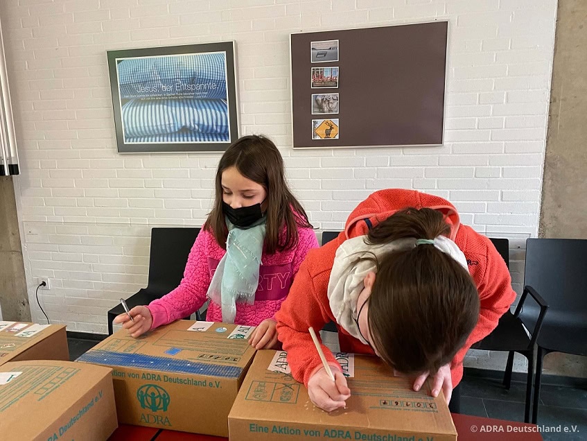 Kerzenverpackung mit Kindern zum Advent, soziale Aktion von ADRA Deutschland.