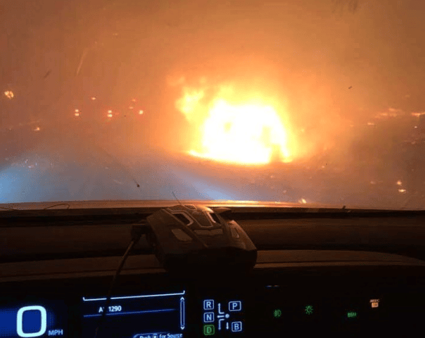 Verkehrsunfall mit Feuer, dramatischer Brandwehreinsatz bei Nacht, Einsatzfahrzeug vor brennender Szenerie, Rettungsdienst und Feuerwehr im Einsatz, Gefahr durch Flammen.