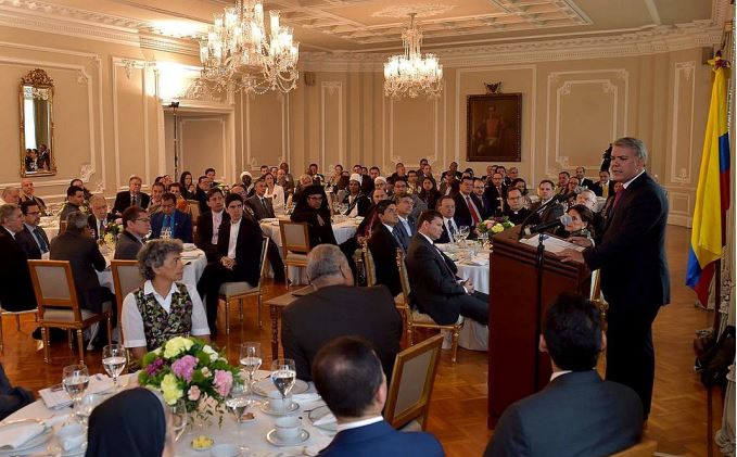 1. Feiern im eleganten Ballsaal mit einem Redner am Pult, umgeben von einem stilvollen Publikum bei einer festlichen Veranstaltung.