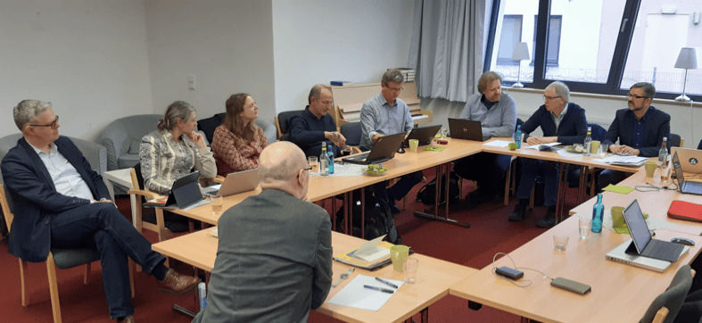 Kleines Treffen im Konferenzraum, Geschäftsleute diskutieren bei einer Besprechung, moderne Arbeitsumgebung, professionelle Zusammenarbeit, Business-Meeting, Teamarbeit, Büro, Kommunikation.