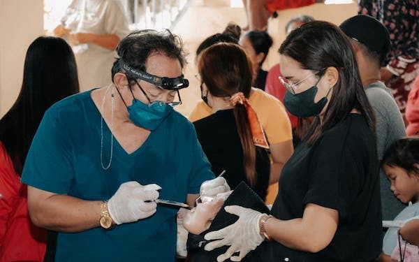 Zahnarzt bei einer zahnärztlichen Behandlung mit Teammitgliedern in einer Praxis, professionelle Mundgesundheit und Patientenpflege, medizinische Versorgung, Zahnpflege, Gesundheit, Dentalhygiene, Arztpraxis.