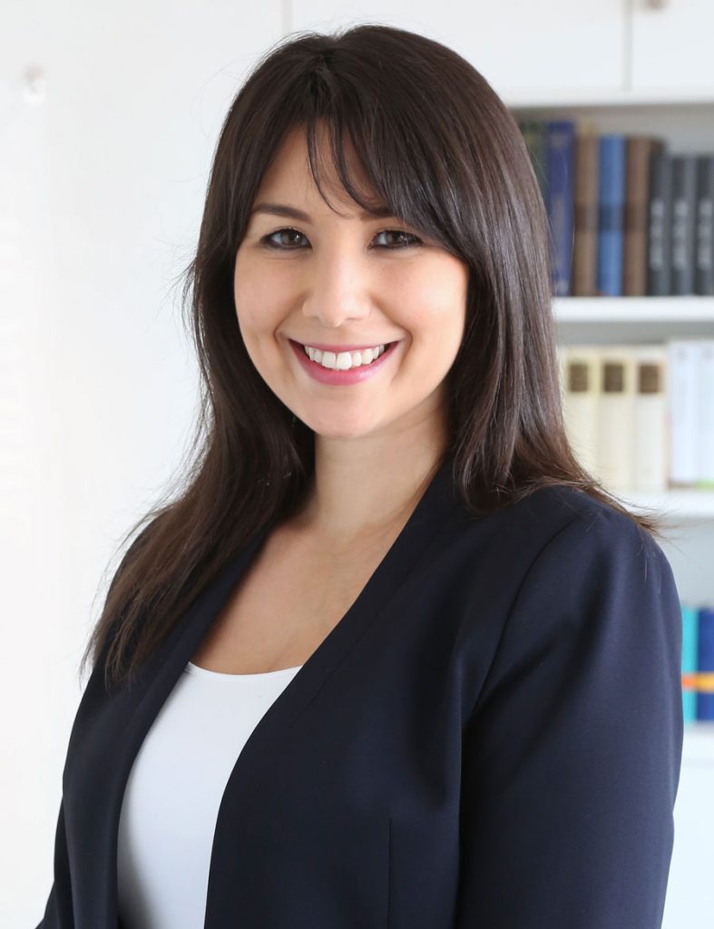 Moderne Frau in Businesskleidung vor Bücherregal, repräsentative Aufnahme für Advent-Verlag, Verlag für christliche Literatur, professionelles Porträt, christliche Bücher, Inspiration und Wissen.