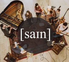Musikgruppe beim Proben im Kreis mit Klavier, Gitarre, Geige und Mikrofon, kreative Musikaufnahme.