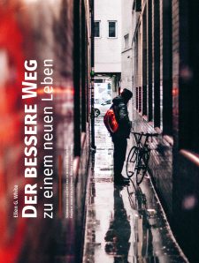 Liegend im Regen stehender junger Mann mit Rucksack und Fahrrad in einer engen urbanen Gasse, symbolisch für reflektierende Atmosphäre und den Alltag in der Stadt.