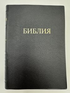Hübsches schwarzes Bibelbuch mit goldgeprägtem Titel in kyrillischer Schrift auf dem Einband, ideal für religiöse Studien und christliche Erziehung.