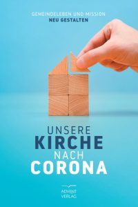 Steinblöcke die ein Haus bilden mit einer Hand, die ein kleines Holzstück darauf platziert, symbolisiert Gemeinschaft und Neues Gestalten nach Corona; Bezug zu Kirche, Glaube, Gemeindeleben.